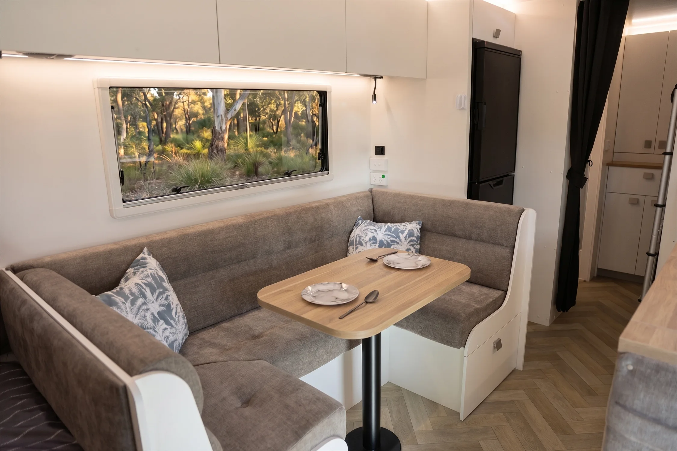 Road Owl club lounge with deep cushions and a picture window looking into the bush