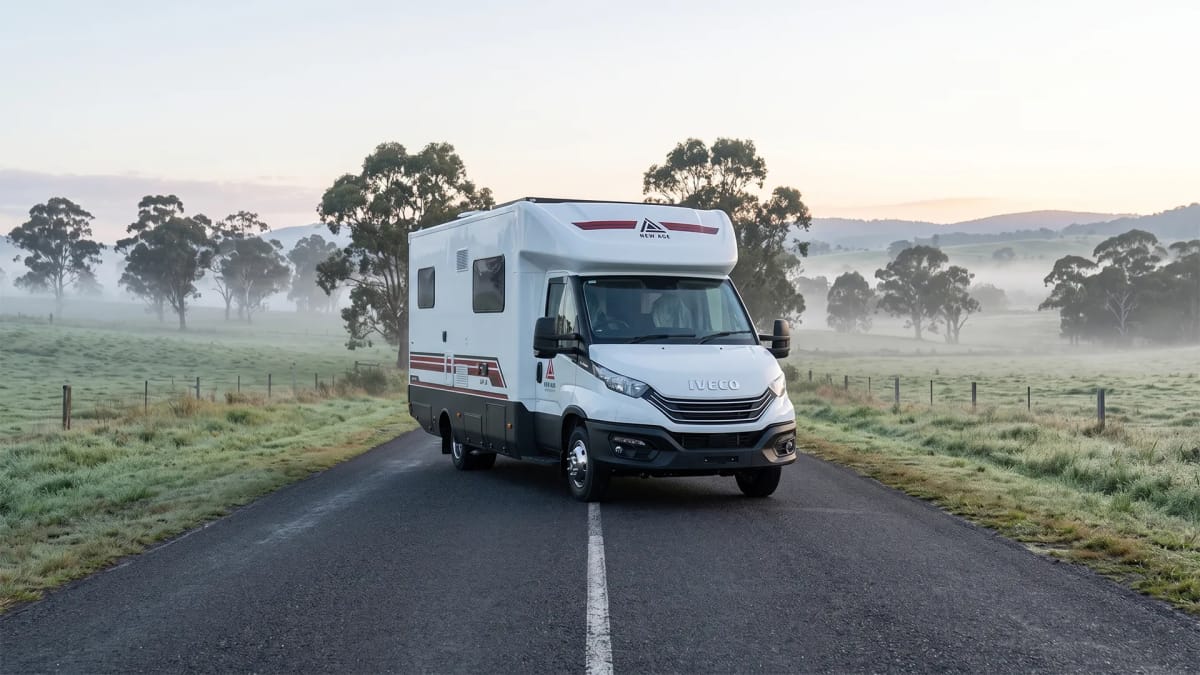 New Age NAM8 motorhome parked on riverside grass at first light